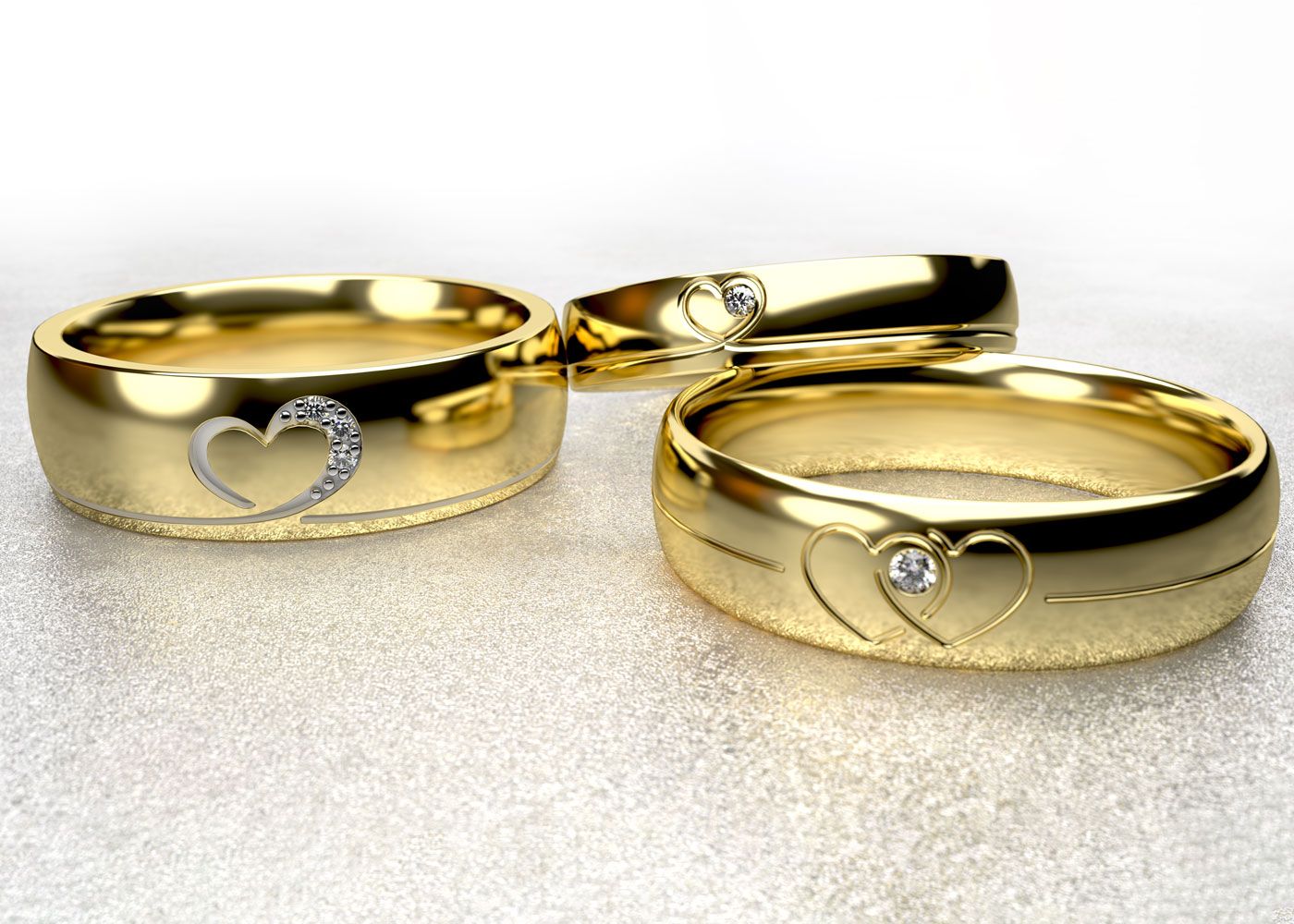 Three gold rings with heart engraings on gradient background