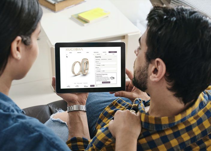 Man and woman looking at an ipad with Kuczora's design center ring configurator on the screen